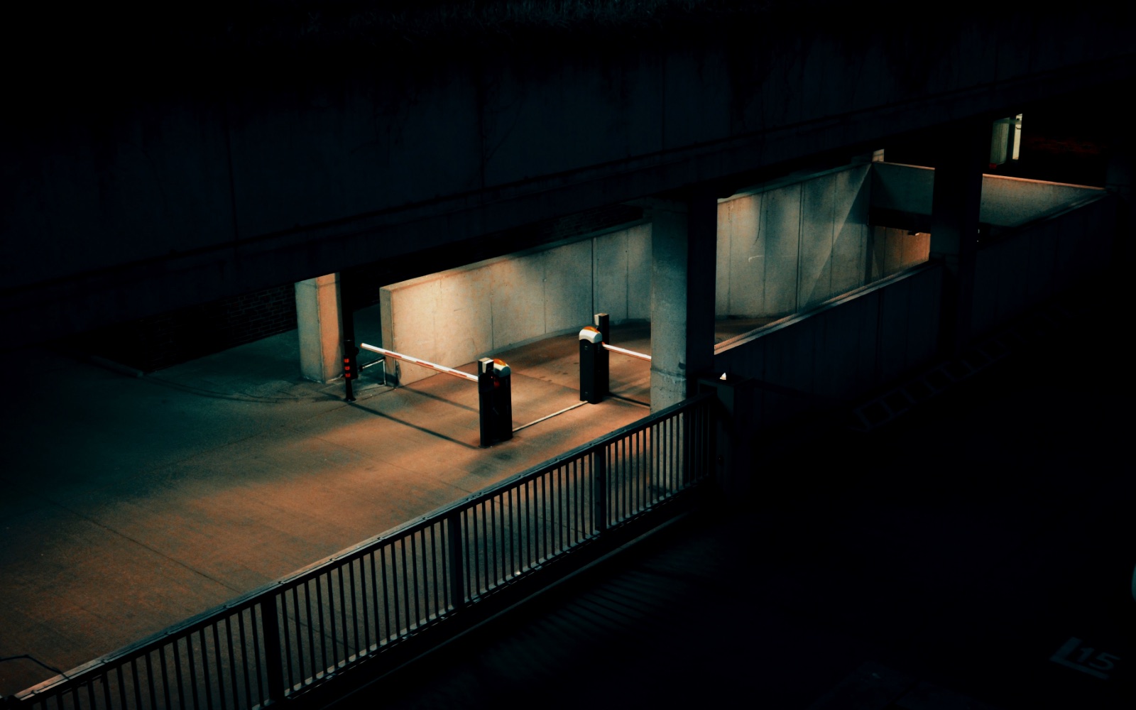 A parking ramp barrier at night under warm light