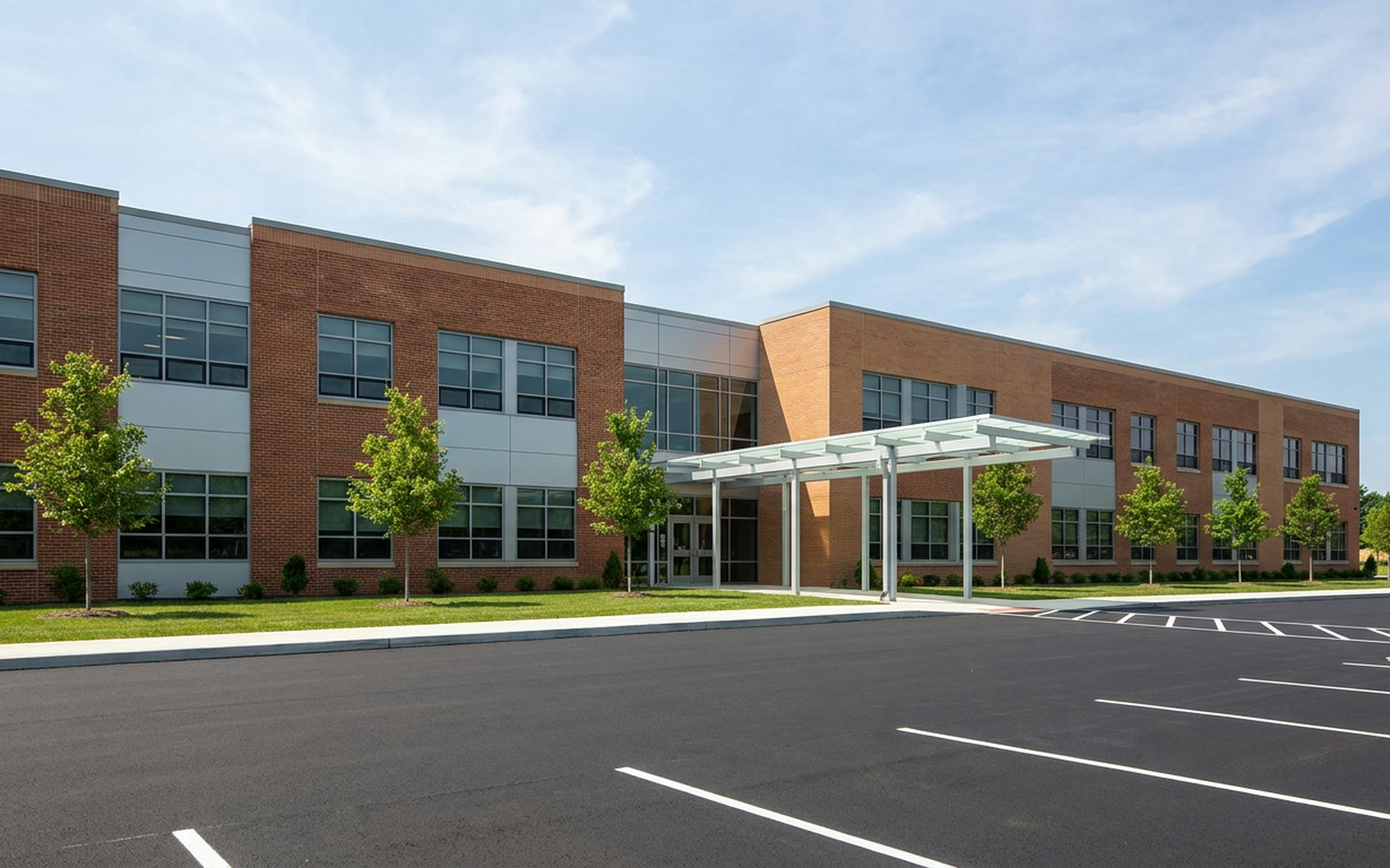 A modern elementary school across its parking lot on a summer day